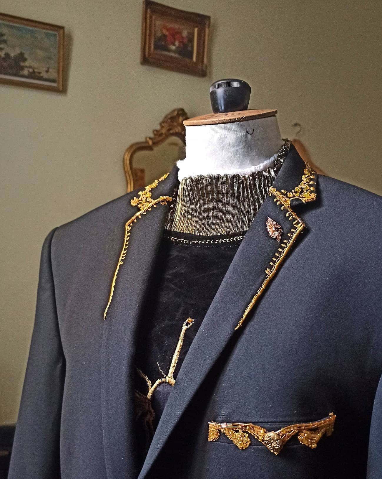 Blazer sombre sur mannequin de couture, col et rabat de poche brodés