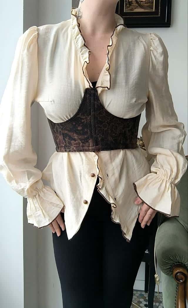 Bustier marron à motif floral porté sur un chemisier crème, vu de face