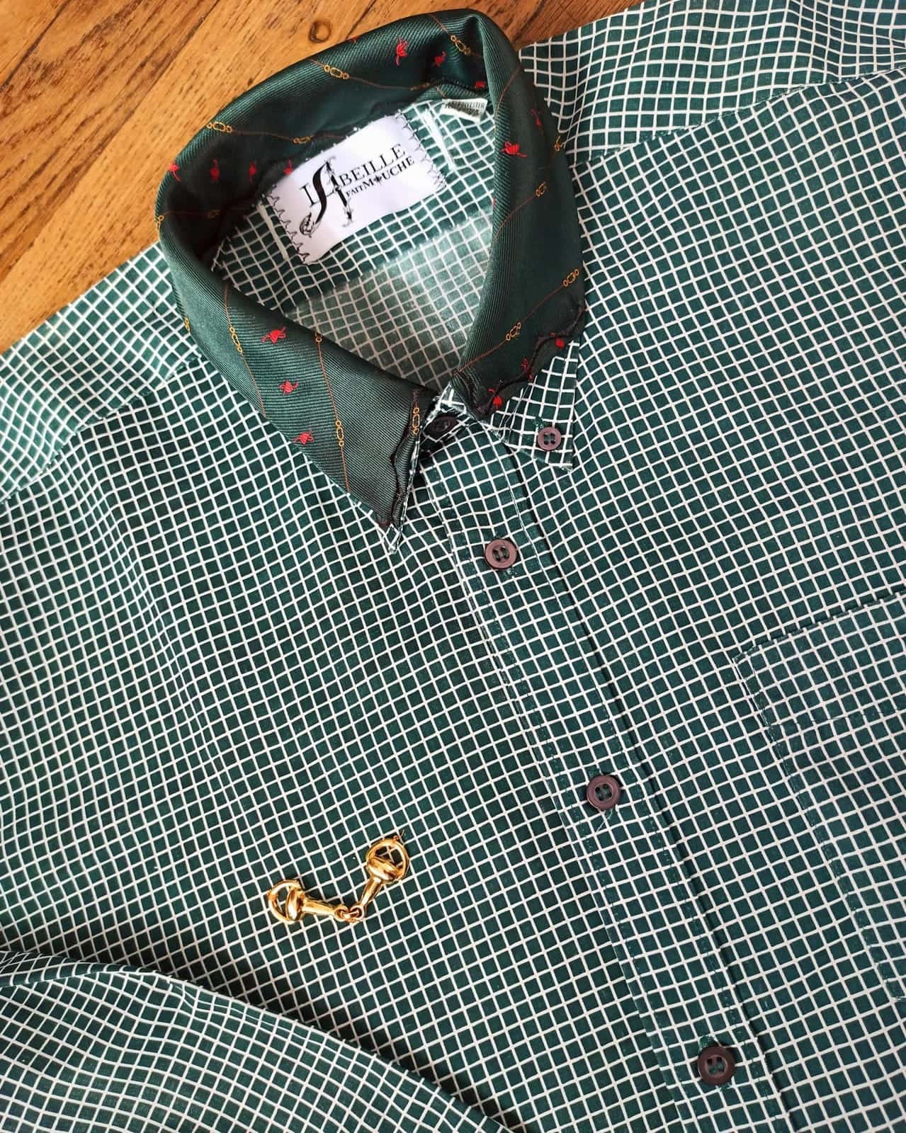Chemise verte à carreaux blancs, col vert sombre à petits motifs, étiquette de la marque et ornement doré sur le devant