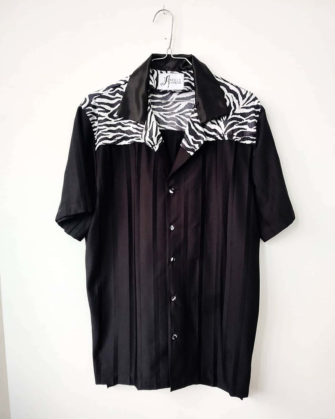Chemise noire plissée, empiècement d’épaules zébré, sur cintre