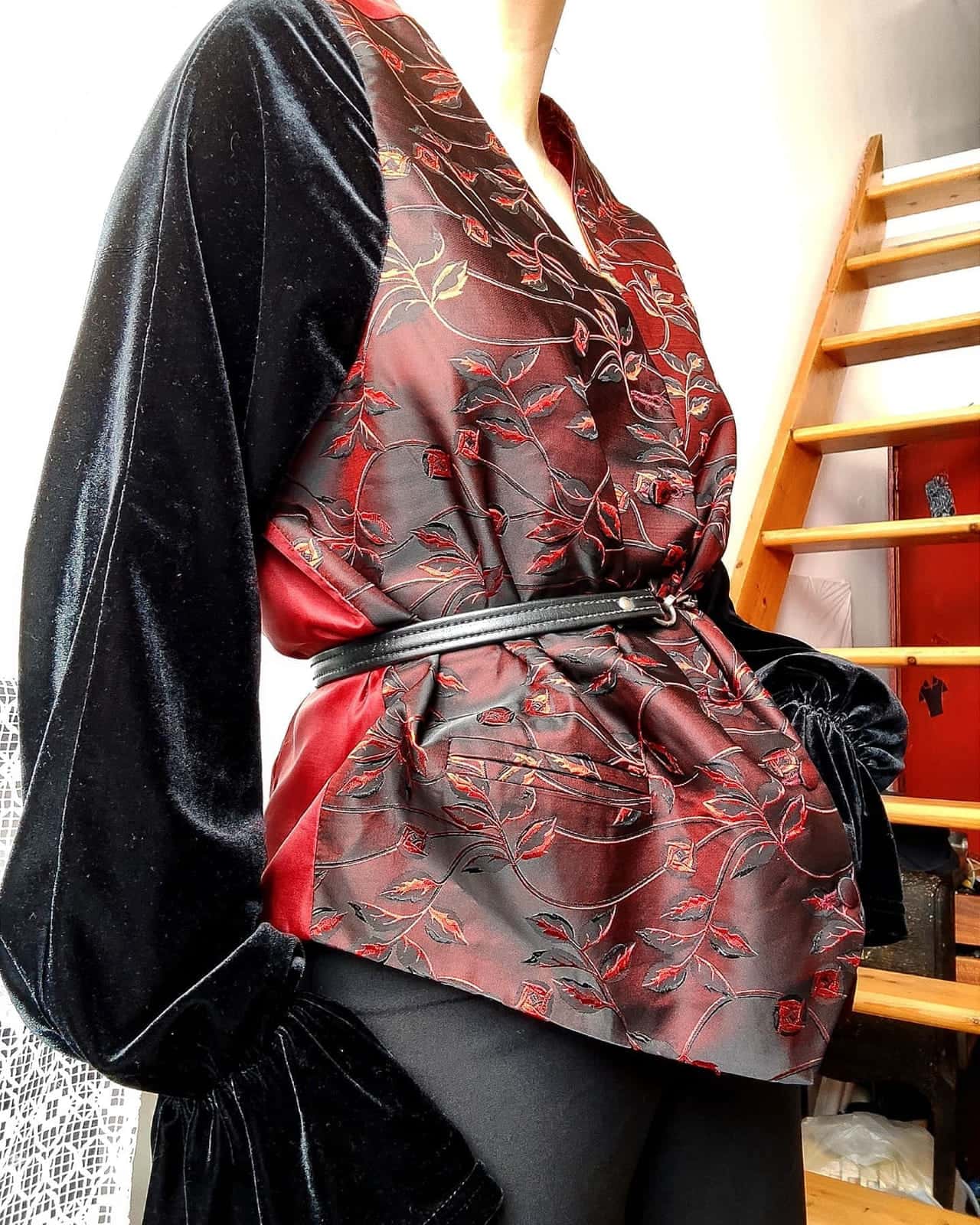 Veste à manches de velours noir et corps en satin rouge à motifs floraux, ceinturée